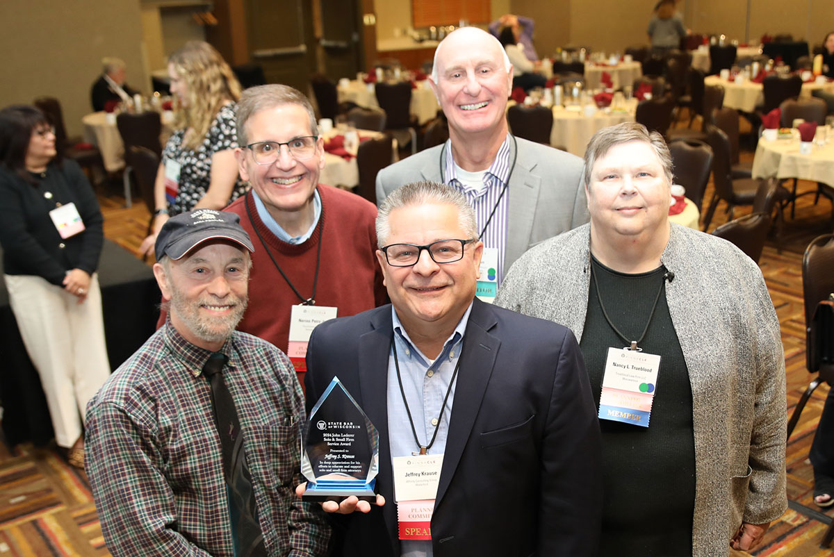 Jeff Krause (center) is the 2024 recipient of the John Lederer Distinguished Service Award. He is surrounded by past recipients, from left: David Krekeler; Nerino Petro; Tom Watson, representing WILMIC; and Nancy Trueblood. 