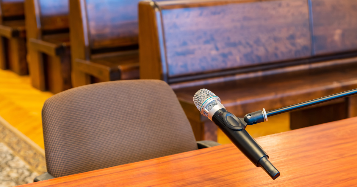Medium Close Up Of An Empty Chair At A Courtroom Witness Table, With Microphone