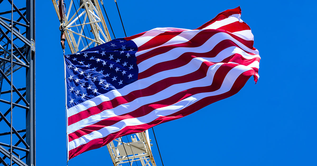 American flag blows in the wind from a construction crane