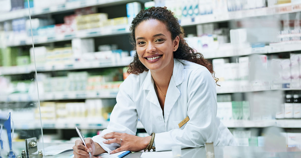 pharmacist smiles from behind counter