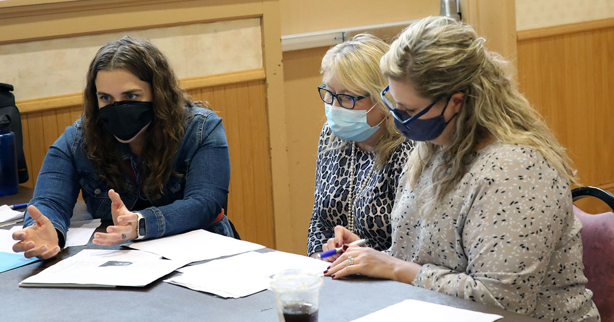 Legal Action of Wisconsin staff attorney Megan Sprecher (left) talks to a client during the 2021 Expungement Clinic in Kenosha. She is joined by State Bar of Wisconsin past president Kathy Brost (center) and Kenosha Bar Association past president Heather Iverson (right). Photo: Shannon Green